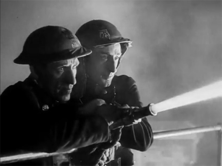 Two firemen from the 1940s aiming a firehose