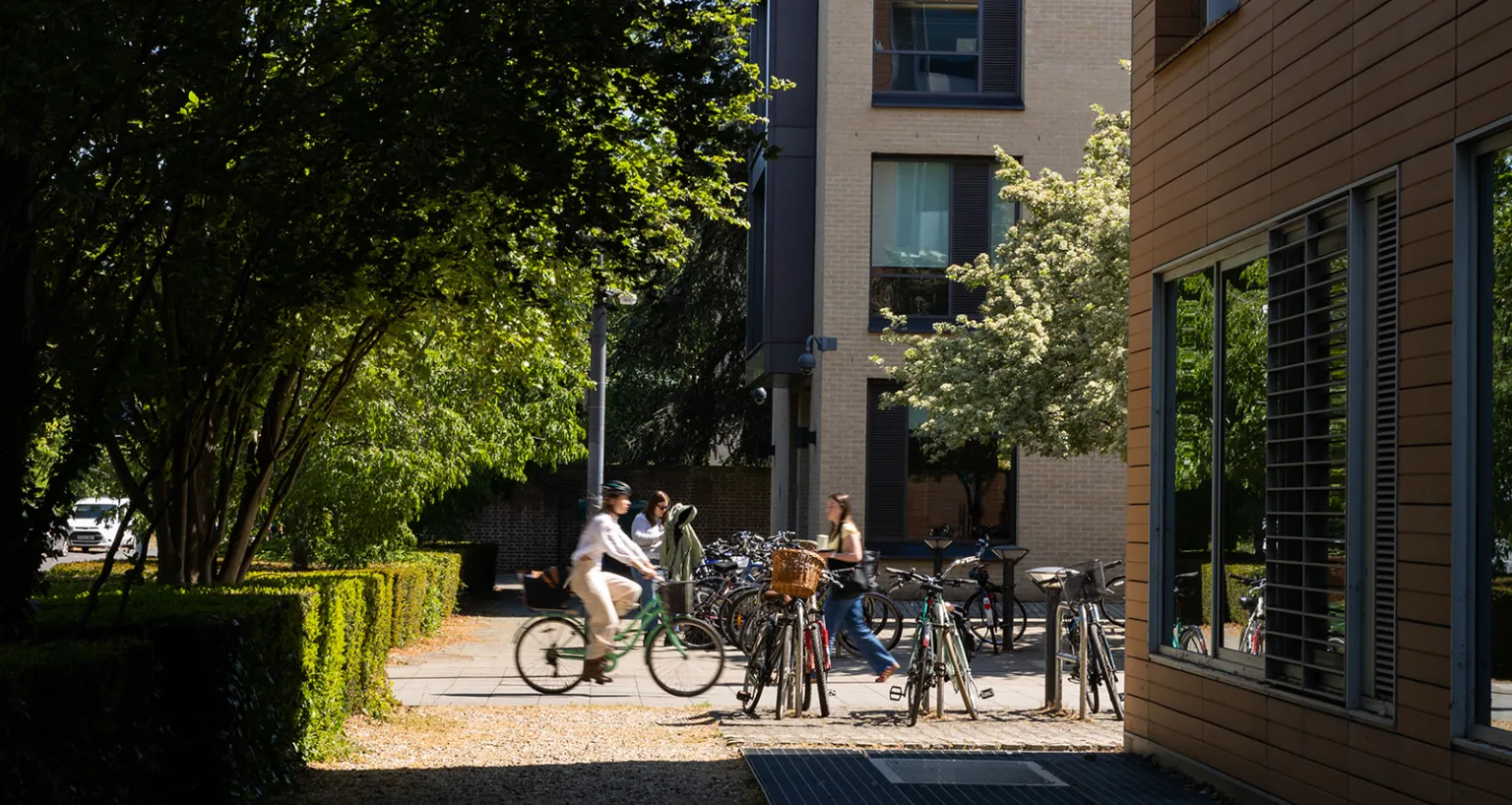 cyclist and pedestrian moving past Faculty building