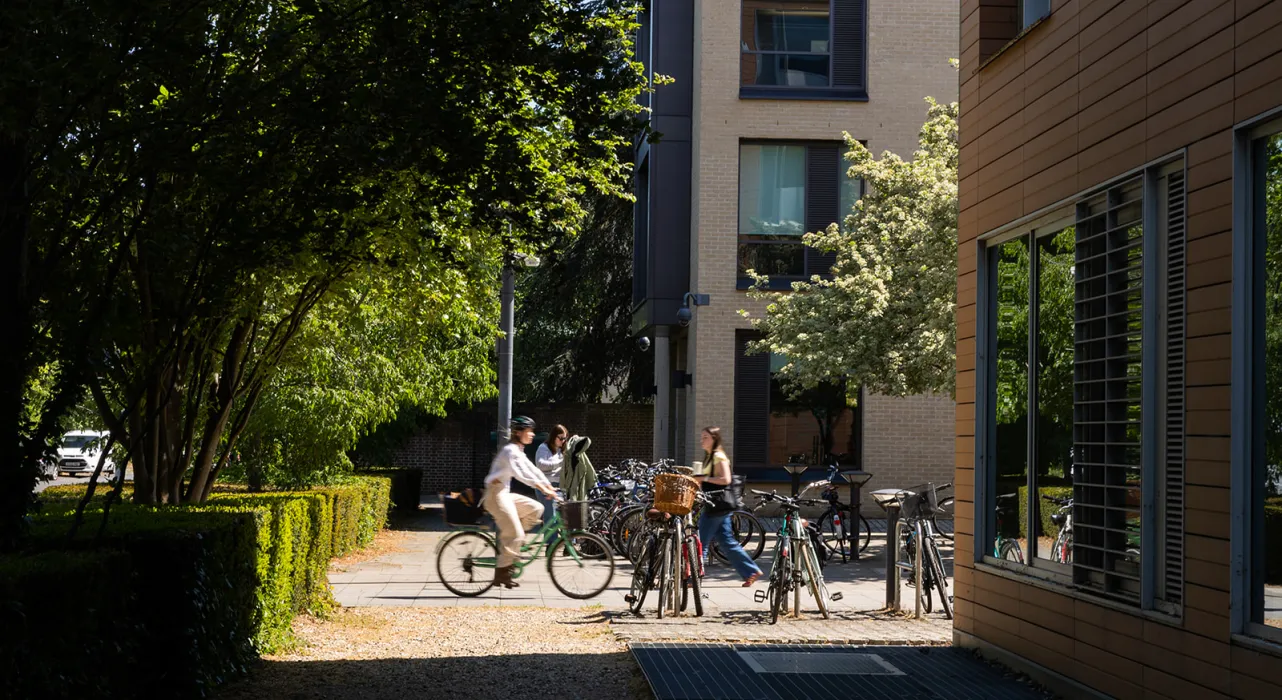 cyclist and pedestrian moving past Faculty building