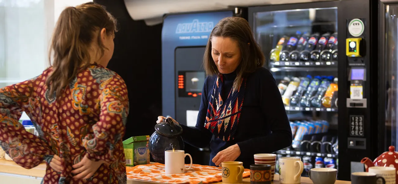 staff member pouring tea for another person