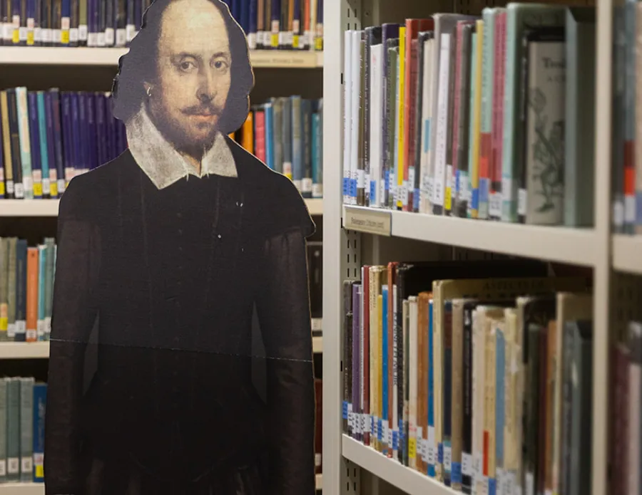 Cardboard cutout of Shakespeare among shelves of books