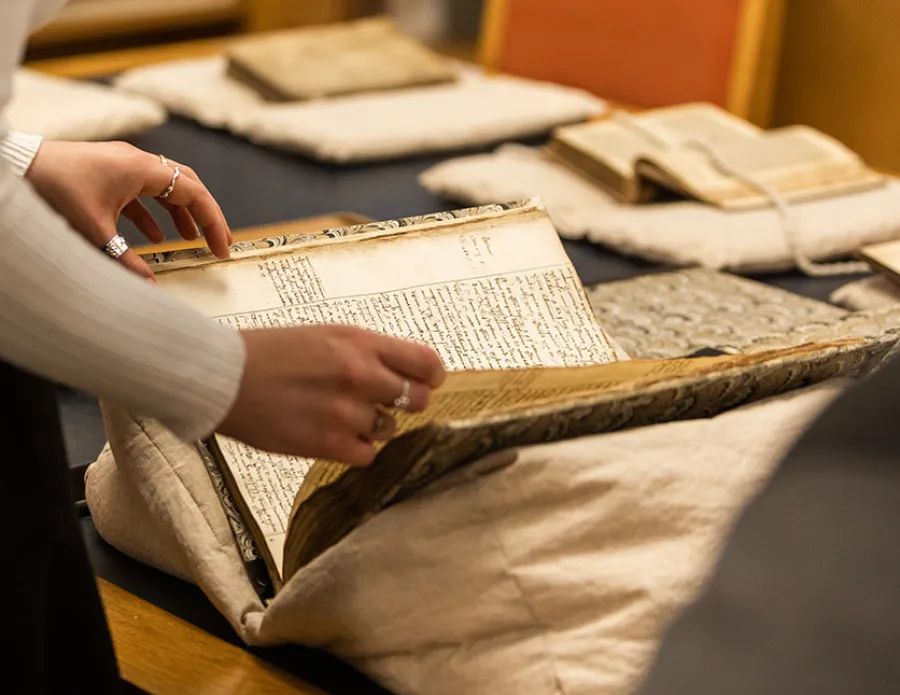 hands opening a manuscript