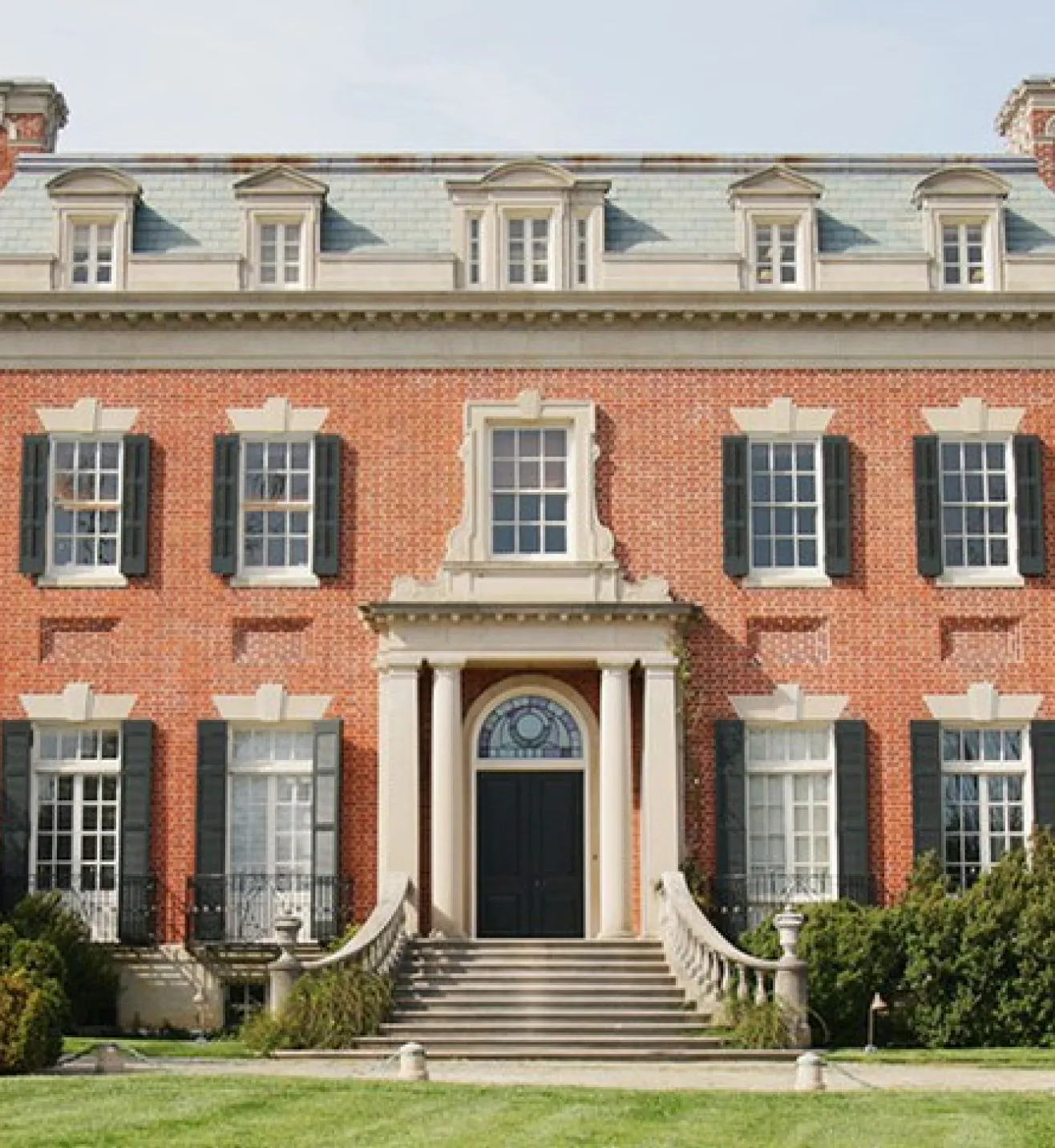 grand redbrick building with extended wings and sweeping steps