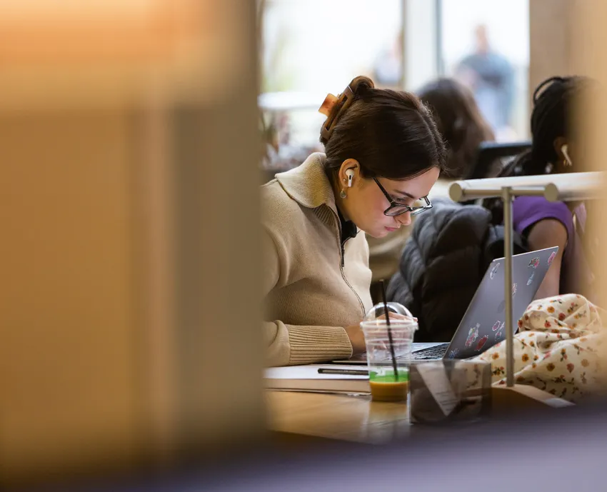 student working at desk with headphones