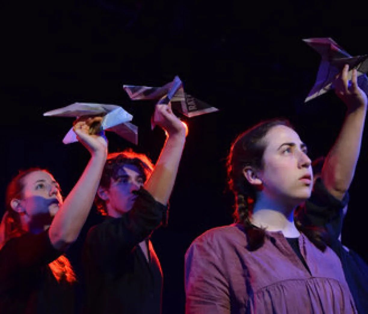 three figures staring into the sky, holding paper airplanes above their heads