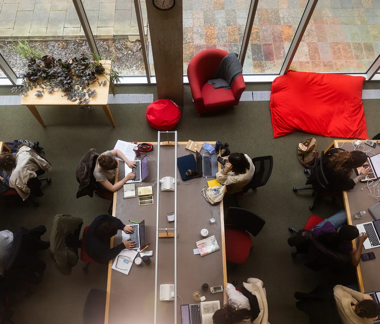view from above of rows of Faculty library desks, pot plants and comfy seating